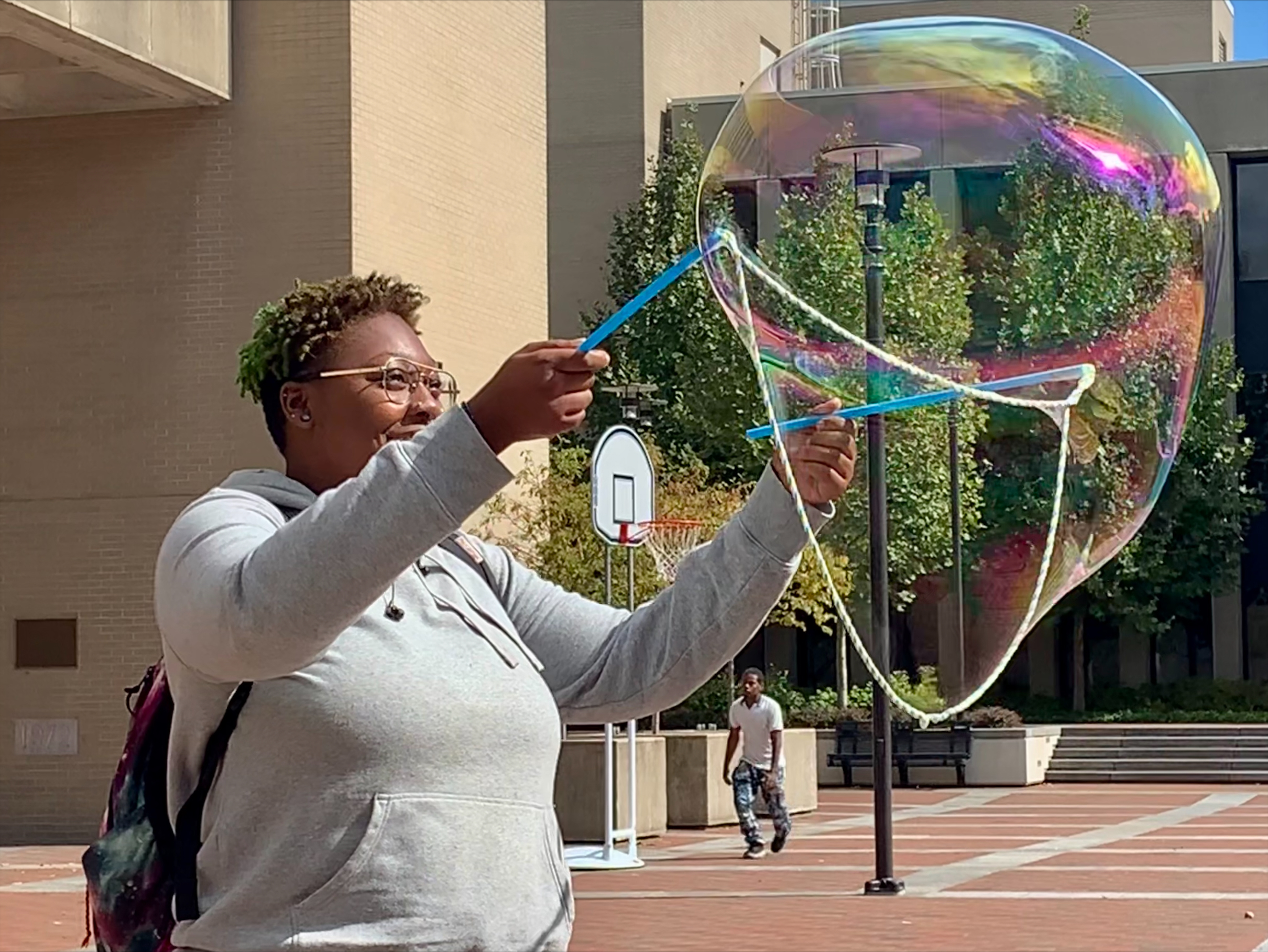 Students and Sinclair's mascot standing in campus plaza.