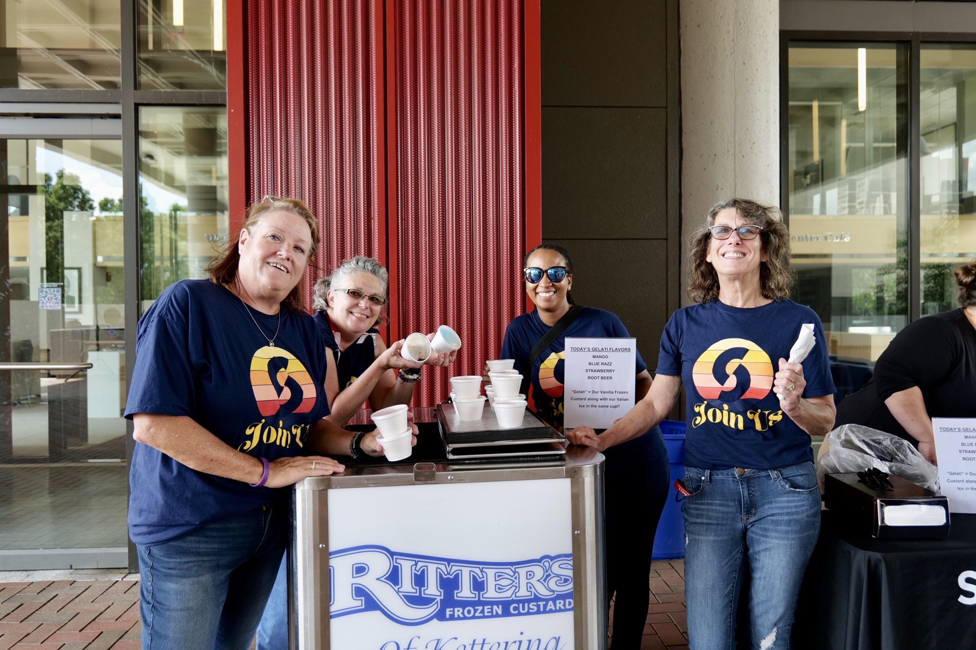 Two staff members standing in front of a Welcome Week information station.