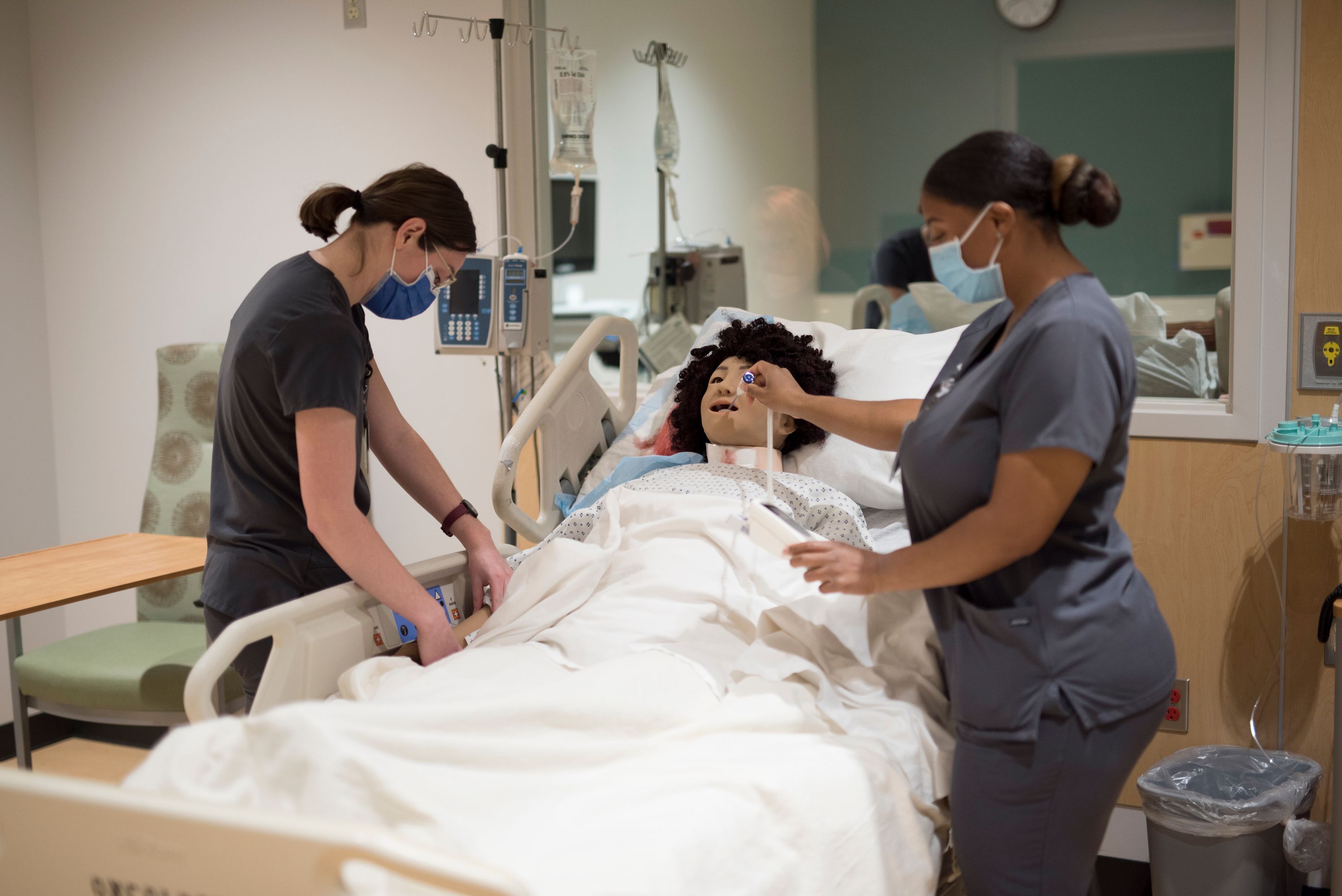 Nurse looking at a mannequin
