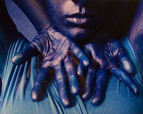 Images of one of Sinclair’s Student Purchase Awards featuring a Blue-toned photograph of hands palm-up  with elbows high in front of a figure’s neck