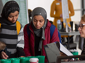 Two international students leaning over a table looking at an event display
