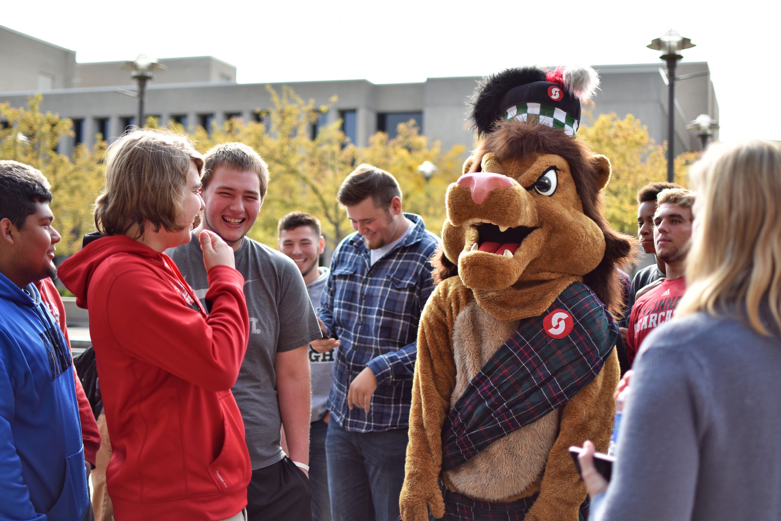 Students and Sinclair's mascot standing in campus plaza.