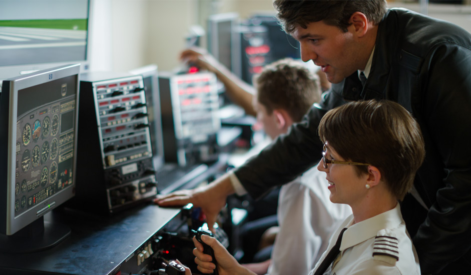 A student and instructor train on one of Sinclair's PCATD flight training devices.