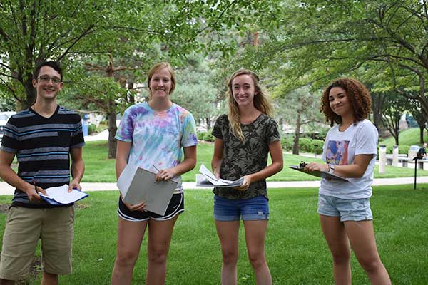 four students on Sinclair's Dayton campus plaza doing homework